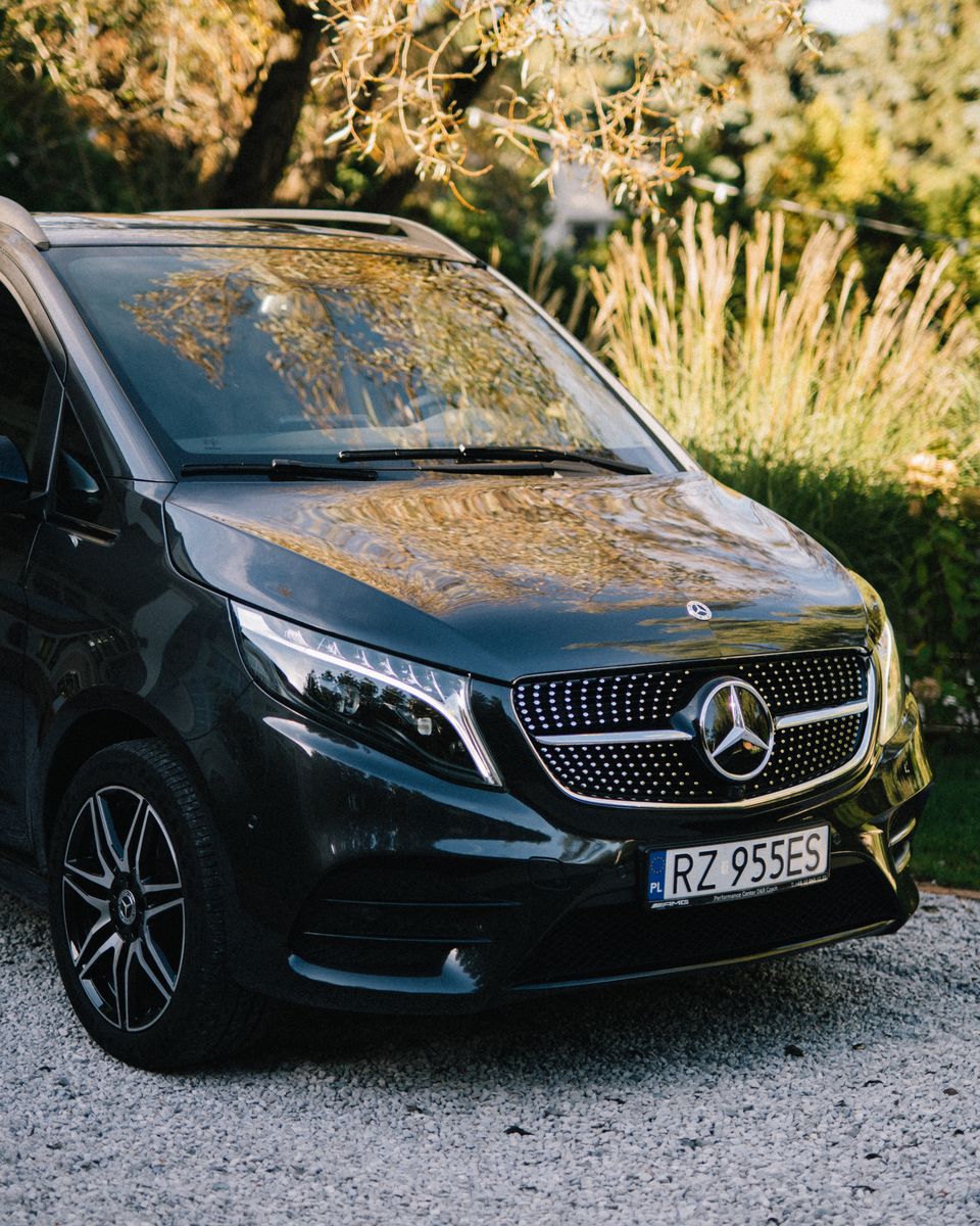 Przód Mercedesa V-Class, widok na maskę i reflektory w naturalnym świetle.